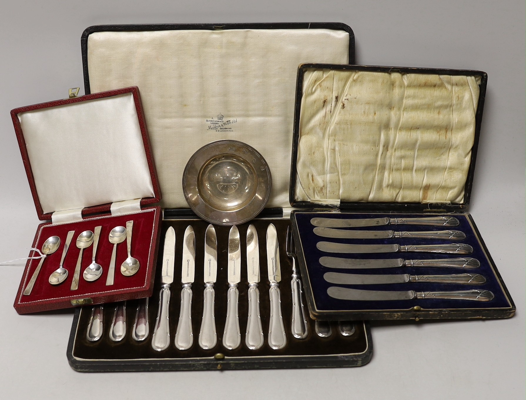 A cased set of six silver coffee spoons, a cased set of six silver-handled dessert knives, a small silver dish and a cased set of plated dessert knives and forks